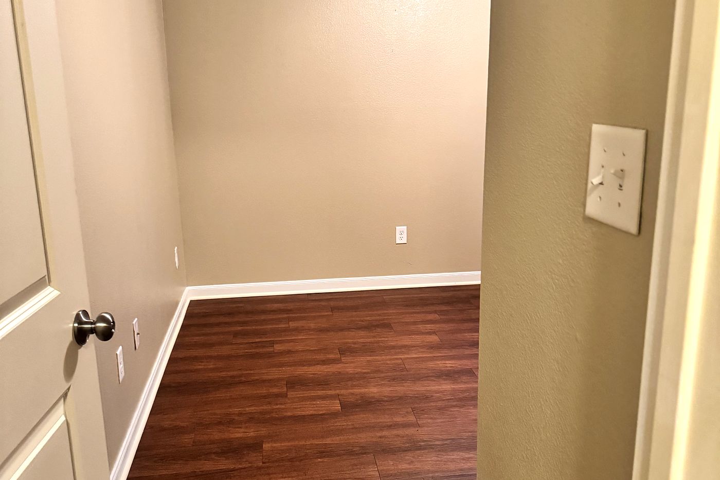 A cleaned hallway and closet, with washed wood flooring and wiped baseboards.