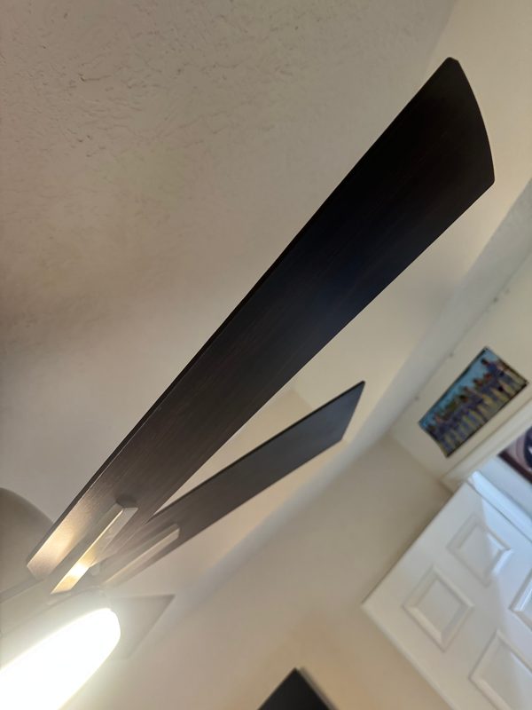 The same ceiling fan blade from the same spot after cleaning, its edge clear of dust.
