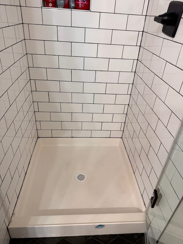 The same shower after cleaning, seen from a little closer, with the pan clear and white.
